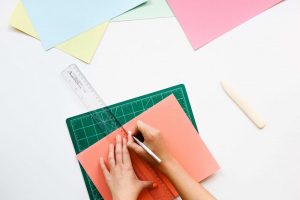 Cutting paper with a ruler and craft knife. Naming Workit Health