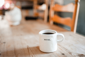 Coffee mug with the word "begin" pressed into the ceramic. Signature non-alcoholic drink