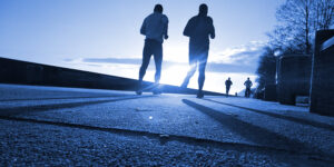 People jogging as the sun comes up over the horizon. Exercise in early recovery