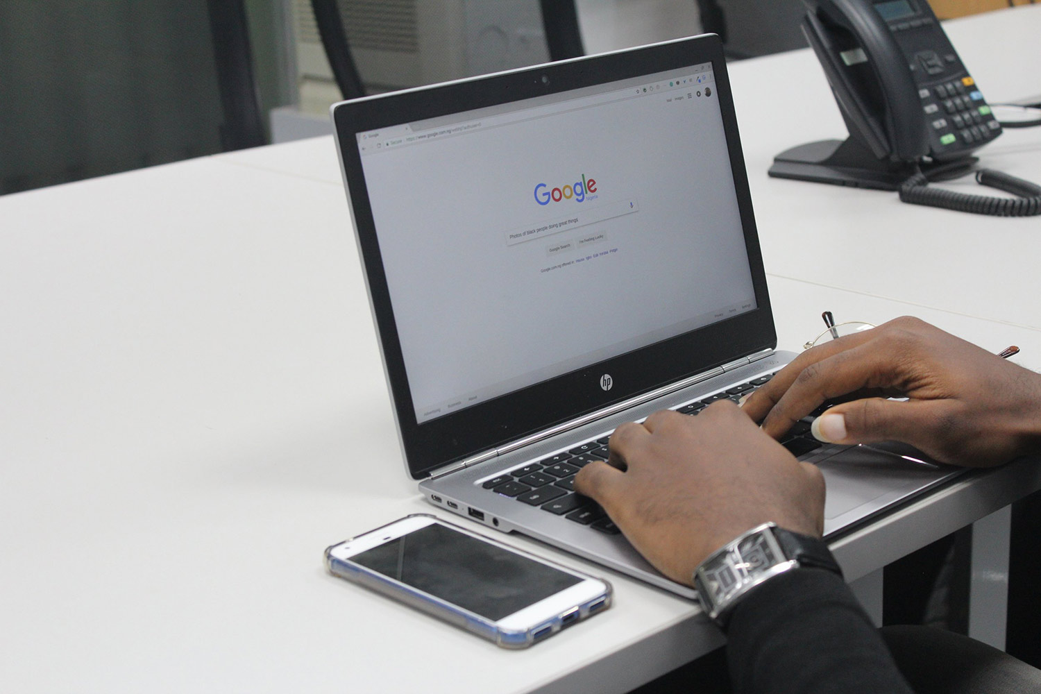 A black man on a laptop using Google