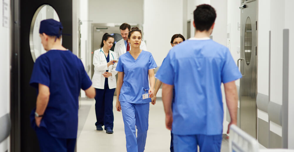 A hospital corridor bustling with medical professionals in scrubs.