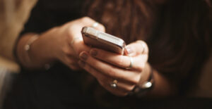 Close up on a woman's hands as she uses a smartphone