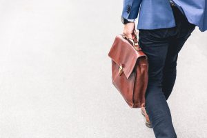 A man in business clothes carries a briefcase. Working when you're in recovery