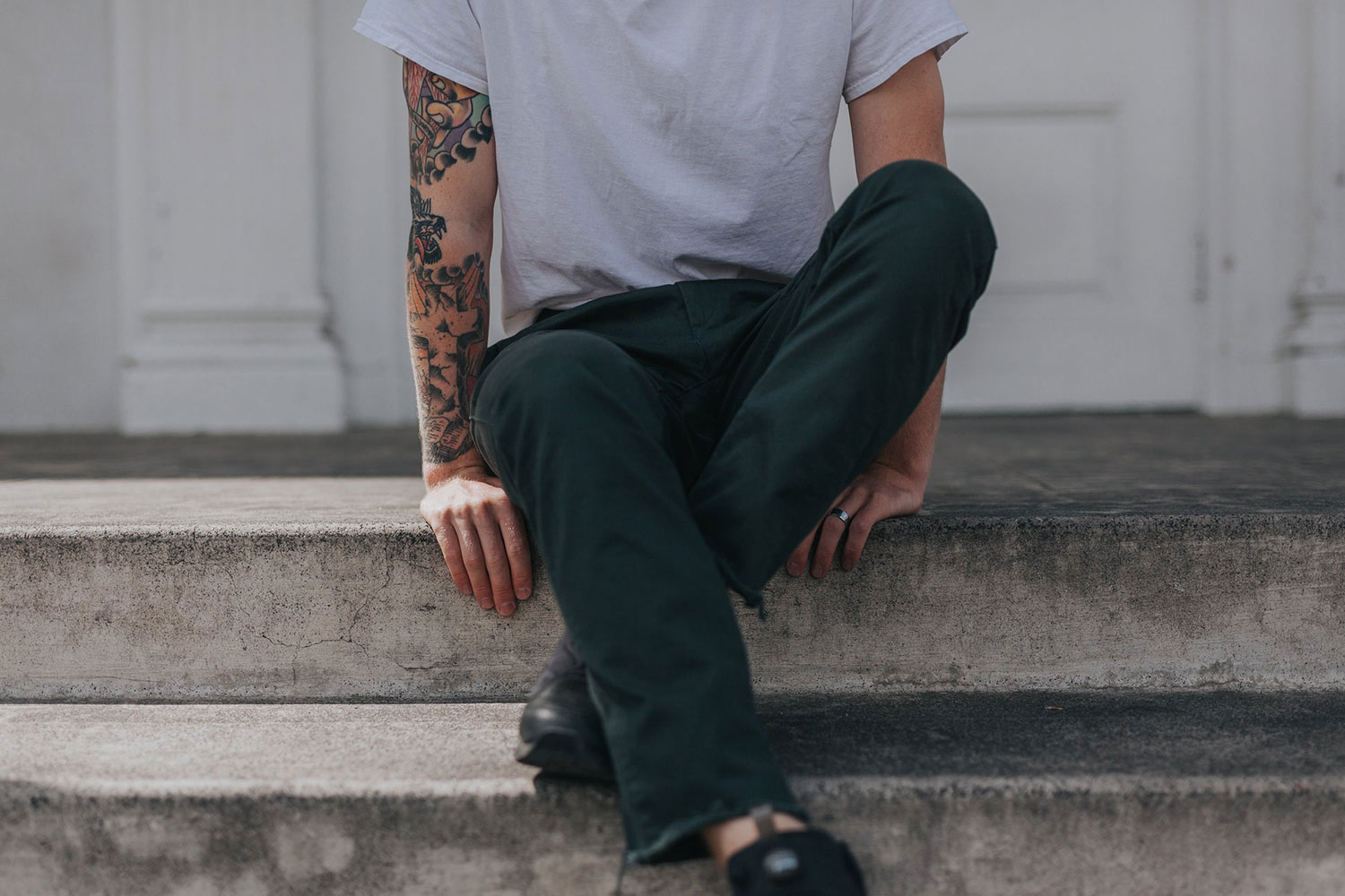 man-with-tattoos-sitting-on-steps