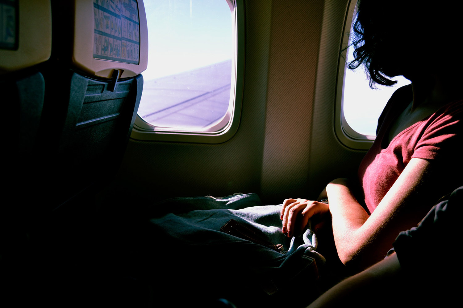 Woman looking out the window of an airplane. Business trips sober