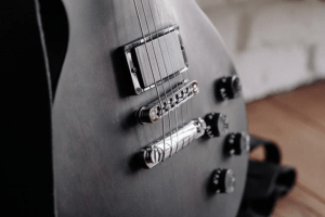 Close-up photo of the belly of a black electric guitar