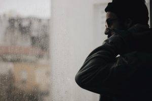 man-looking-outside-at-the-rain