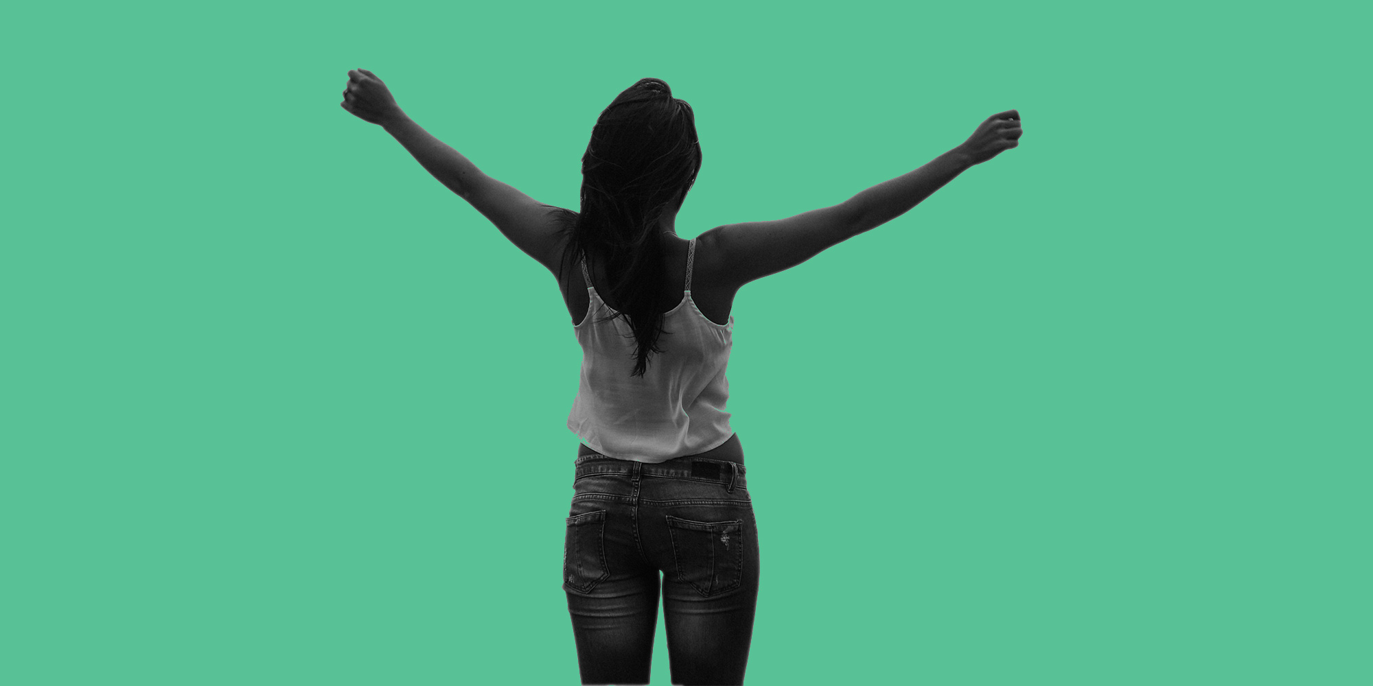 View from behind of a woman with her arms raised in joy