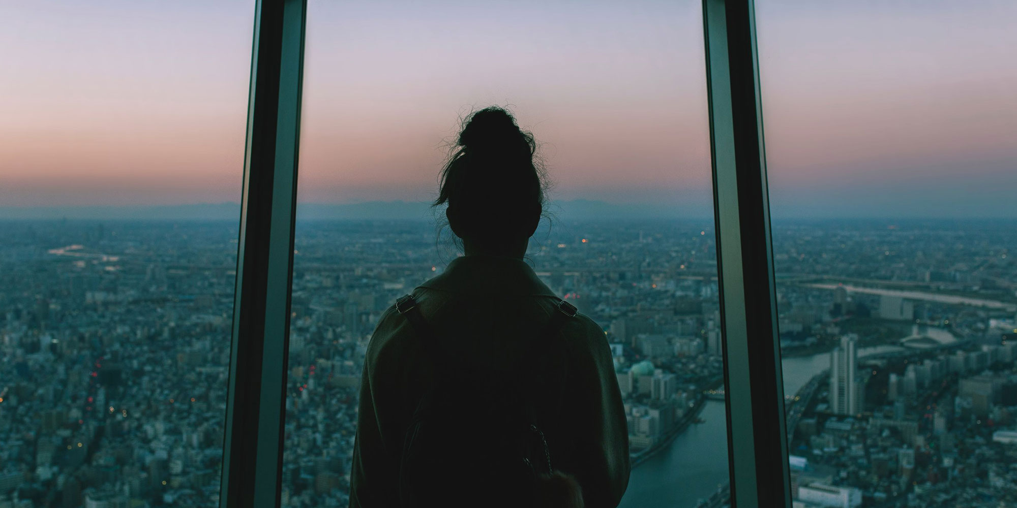 Back view of a person staring out a window