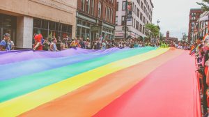 A rainbow flag fills the street at a Pride event