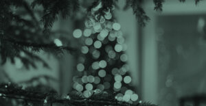 Out of focus image of a Christmas tree, twinkling with lights, with a green overlay on the image. There's no place like sober for the holidays.