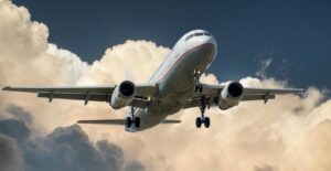 A passenger plane flying in front of a cloud