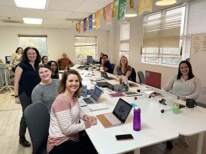 The Workit Health team working at laptops around a long conference table