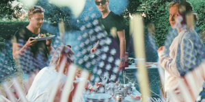 People at an outdoor barbecue. The image is overlaid with American flags.