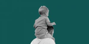 Small child on his father's shoulders. Recovery shapes fatherhood