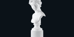 Classical bust sculpture of a lovely woman with a peaceful smile, carved from white marble.