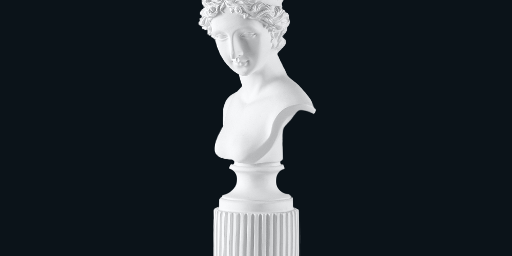 Classical bust sculpture of a lovely woman with a peaceful smile, carved from white marble.