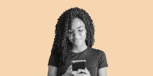 Young woman smiling at her smartphone. How Telemedicine for Addiction Treatment Works