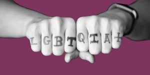 Hands with LGBTQIA+ written across the knuckles