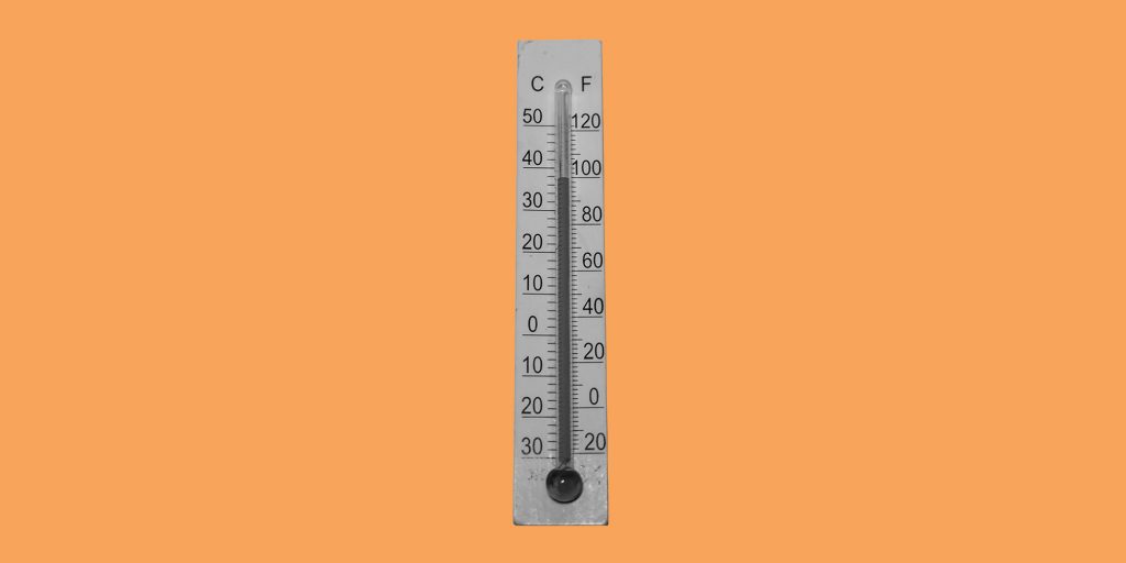 Thermometer on an orange background. Staying sober when the weather is hot