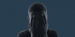 Man covering his face with his hands, depression