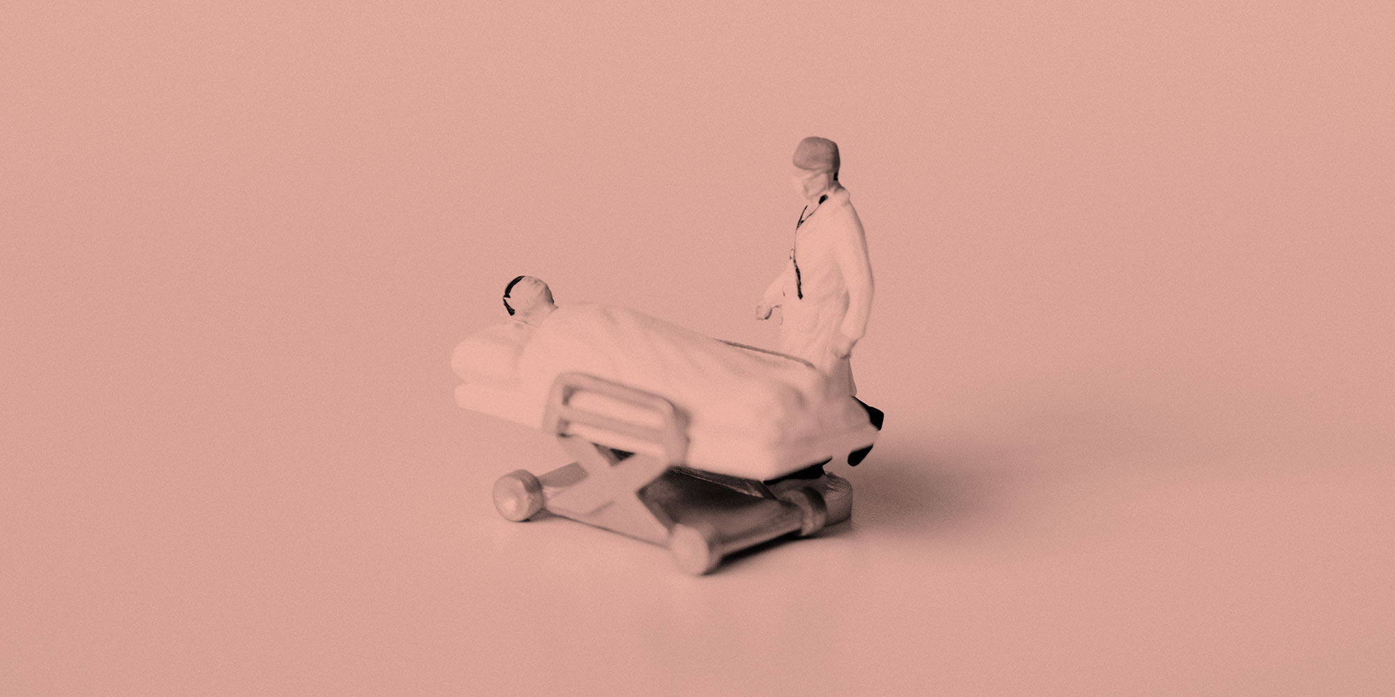 Figure of a doctor beside a patient in a hospital bed. Post-surgery medication and addiction recovery