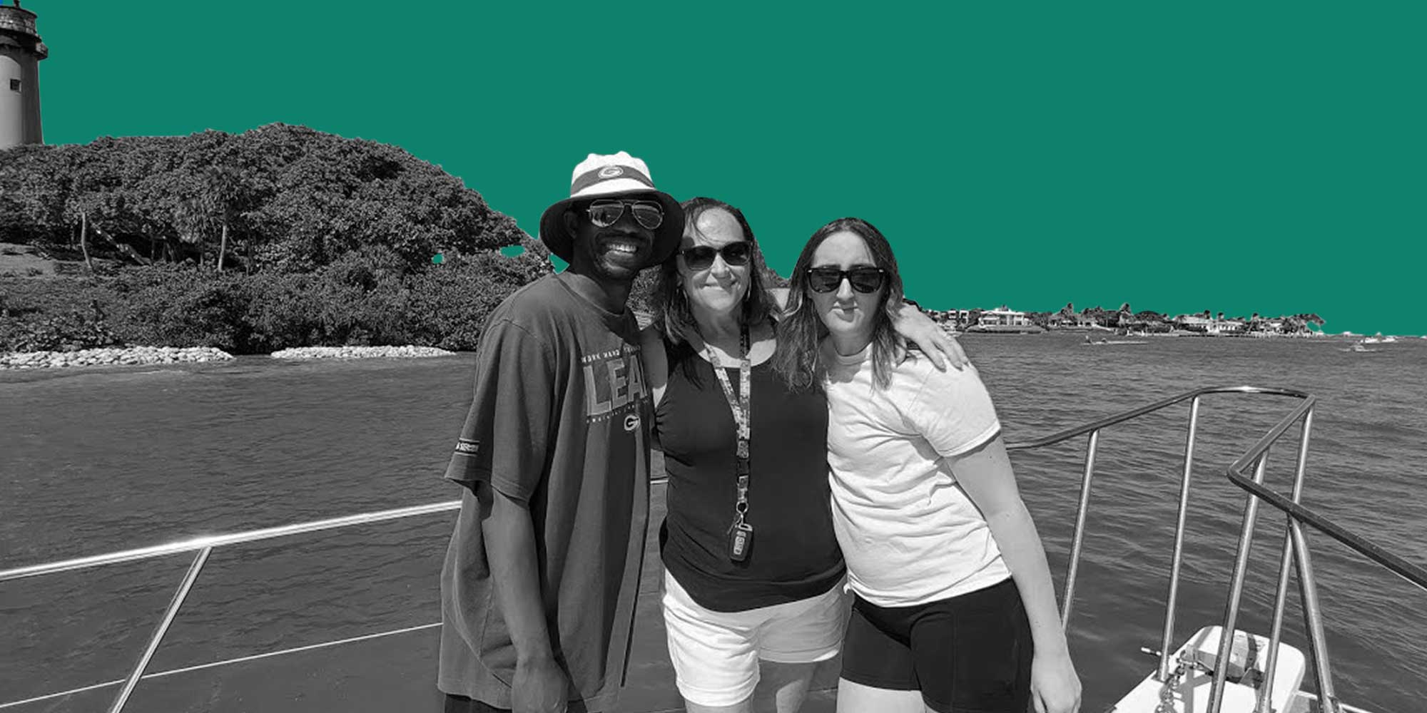 A family of one African American man and two White women on a boat