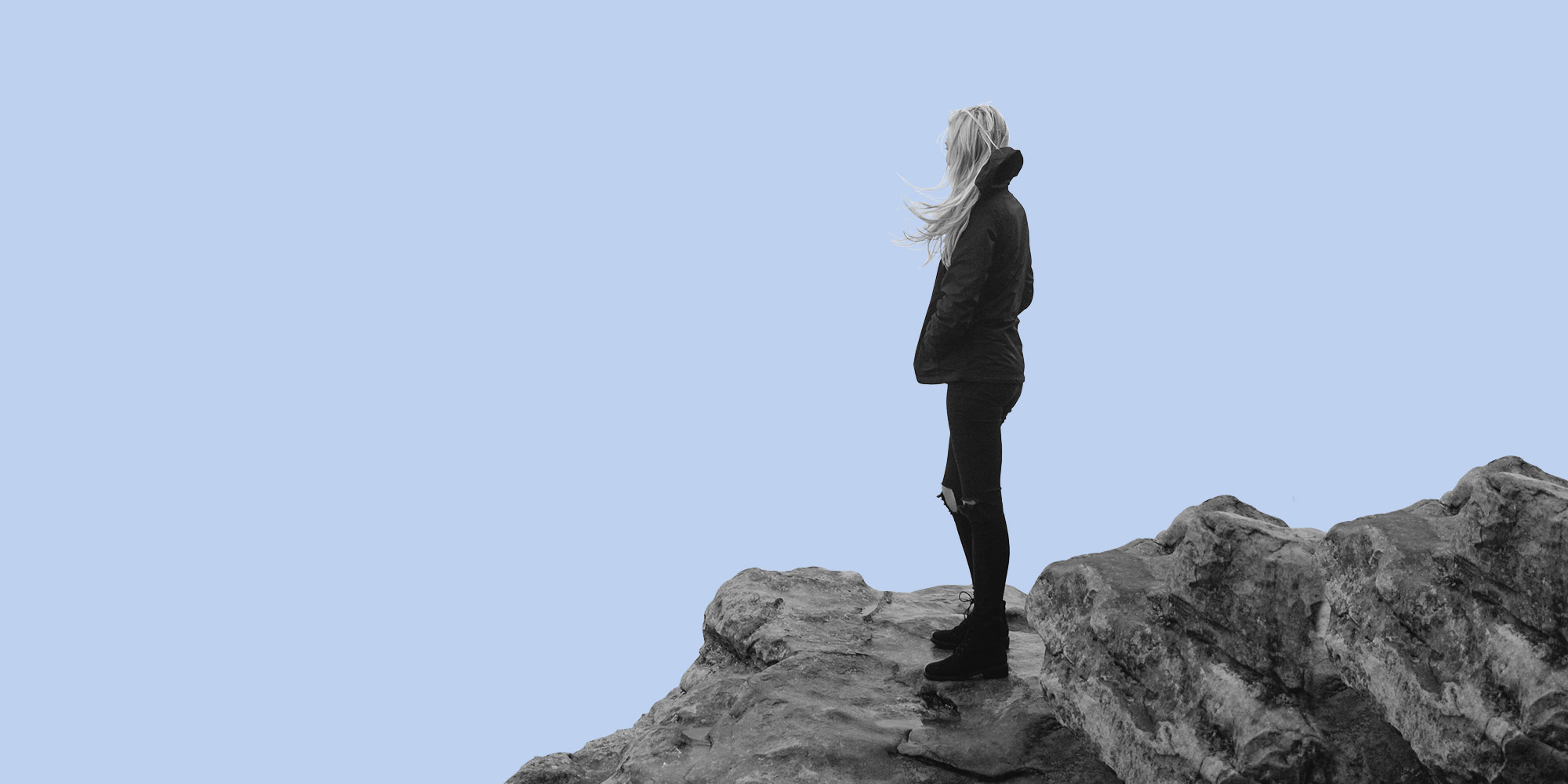 Woman alone on rocks. Does alcohol make anxiety worse?