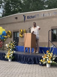 Freddy Shegog standing at a lectern on an outdoor stage, addressing the class of 2021.