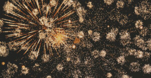 Golden fireworks exploding across a black night sky