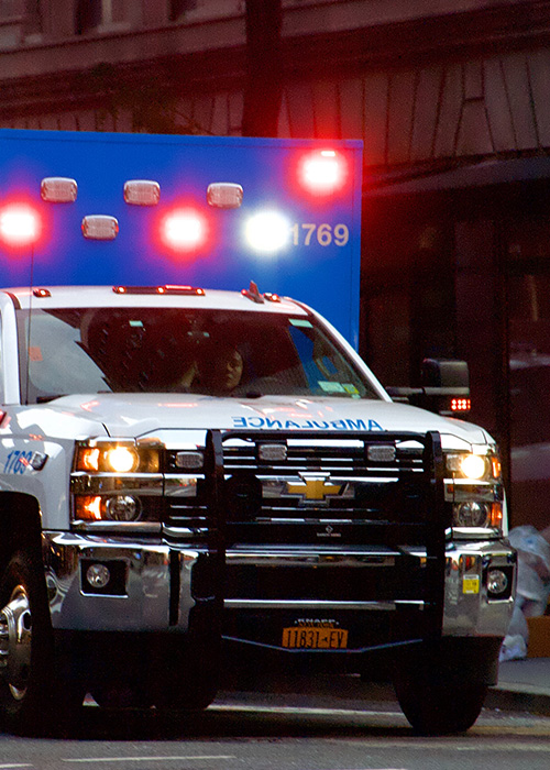 ambulance driving down street with light on help someone is distress