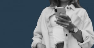 Woman using a smartphone against a dark blue backdrop