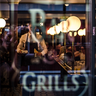 Restaurant window, inside a server and patrons can be seen