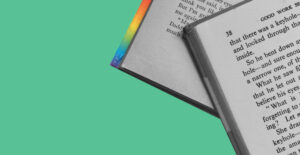 Books with rainbow binding against a green background. Pride reading list