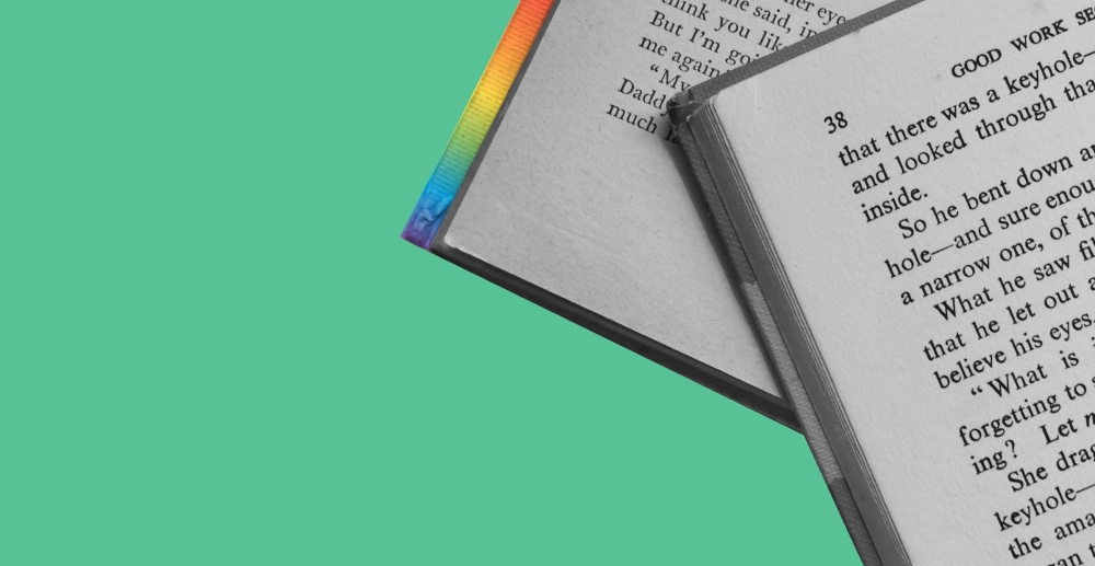 Books with rainbow binding against a green background. Pride reading list