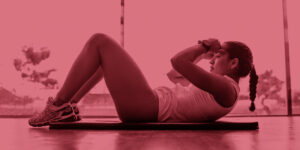 Woman doing ab crunches on the floor in front of large windows. Workit out at home