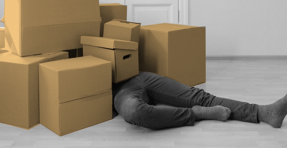 Person bried under a pile of cardboard boxes. Staying grounded during a move.