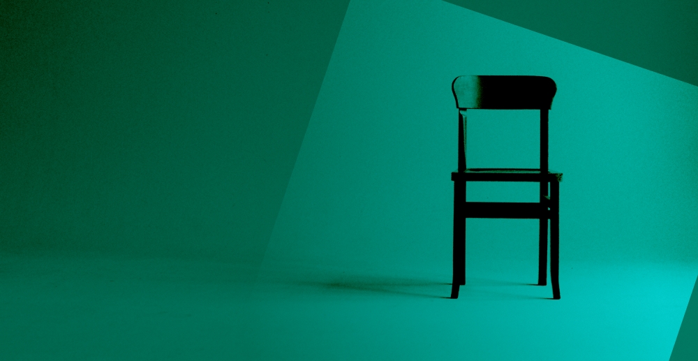 An empty chair standing alone, with a green color overlay. Why I left AA