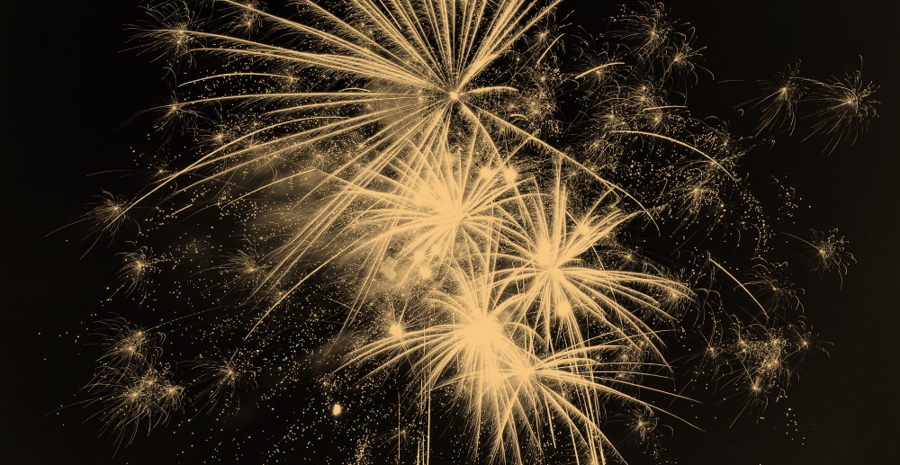Yellow fireworks against a black sky. Plan your sober new year's.