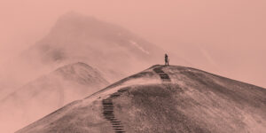 A person stands on a hilltop with stairs below them, cut into the side of the hill. Lessons learned at 10 years of recovery.