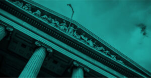 Green color overlay on a black and white photo looking up at a courthouse decorated with carved figures and pillars. Post-COVID regulations and telemedicine addiction care