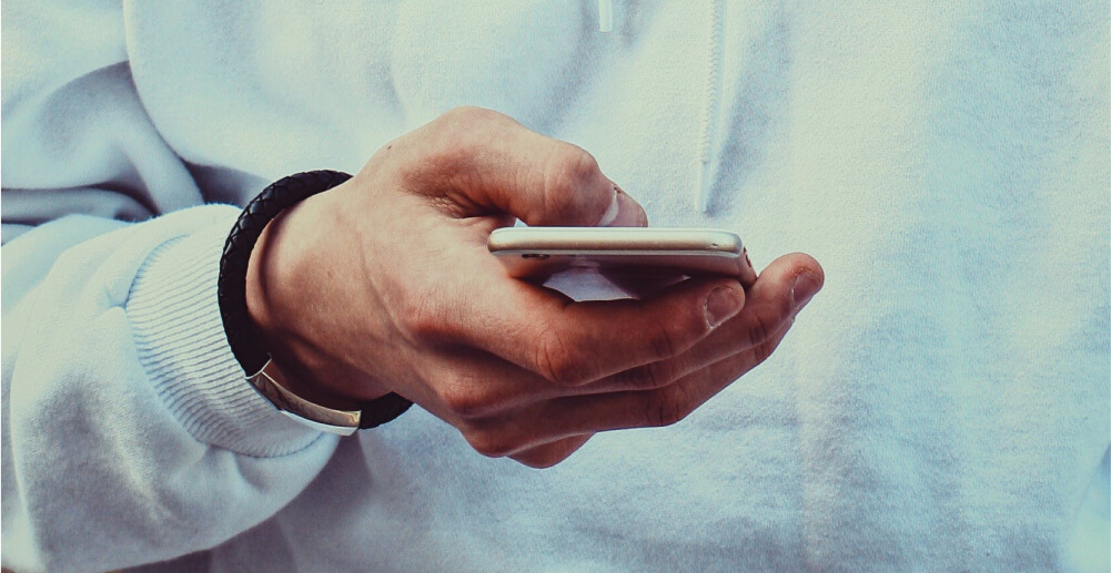 A man's hand using a smartphone