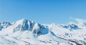 Snowy mountain peaks beneath a clear blue sky.