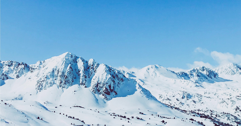 Snowy mountain peaks beneath a clear blue sky.
