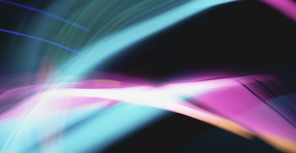 A blur of neon light in shades of cyan blue and pink against a black background.