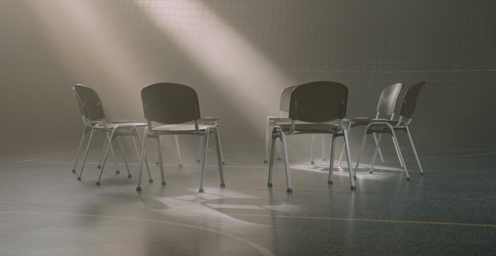 An empty circle of chairs in an empty gym.