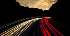 A long-exposure picture makes headlights and taillights of cars look like fast streaks of white and red.