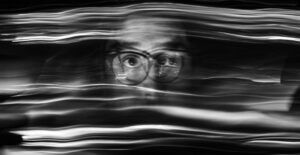 A blurry, smeared black and white photo of a man's face.
