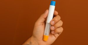 Hand holding a GLP-1 injector pen.