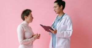 A tall female doctor speaks to a shorter female patient